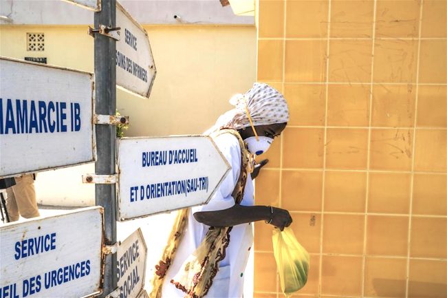 A-nurse-walks-past-the-entrance-of-Fann-hospital-in-Dakar-Senegal-on-March-27-2020-xinhua-650x433