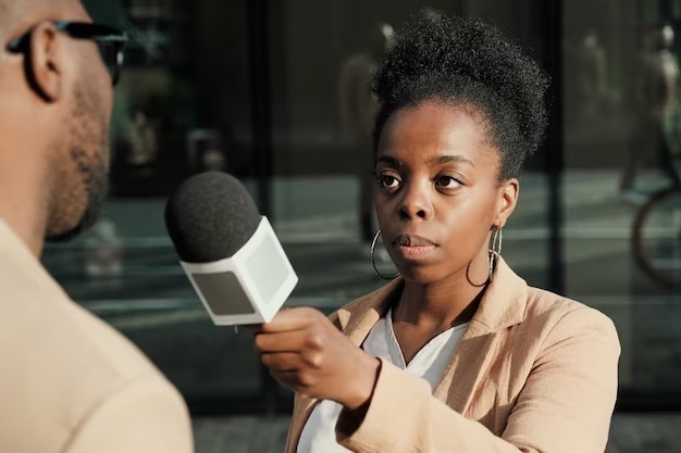 journaliste-africaine-tenant-microphone-interviewant-homme-exterieur_249974-5649JPEG